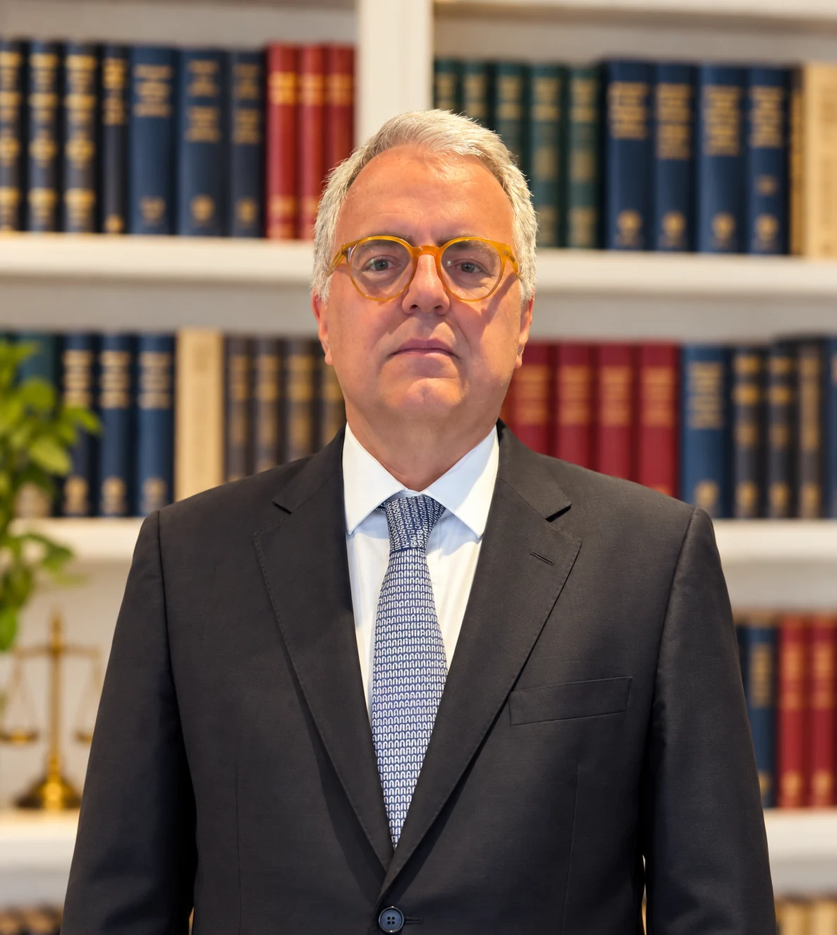 Retrato profissional do Dr. Paulo Carvalho Caiuby diante de uma biblioteca jurídica.